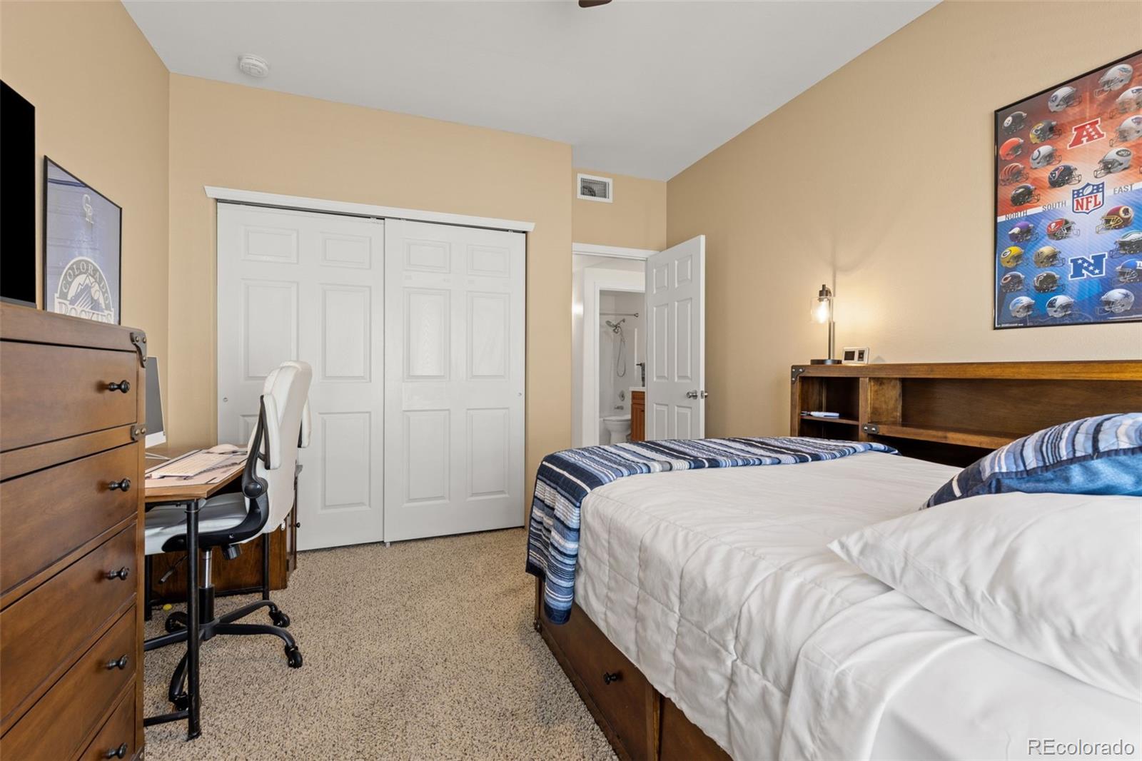 8334 Pebble Creek Way, Unit 201 Highlands Ranch, CO 80126 - Photo 21 of 28 a bedroom with a bed a desk and chair
