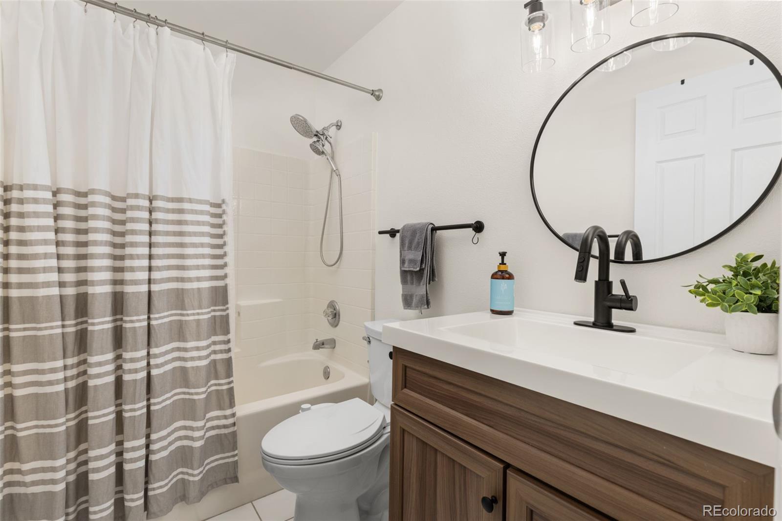 8334 Pebble Creek Way, Unit 201 Highlands Ranch, CO 80126 - Photo 22 of 28 a bathroom with a sink a toilet and shower