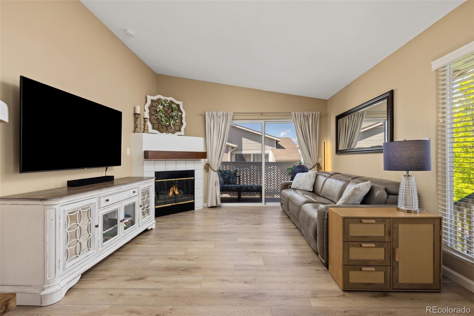 8334 Pebble Creek Way, Unit 201 Highlands Ranch, CO 80126 - Photo 3 of 28 a living room with furniture a flat screen tv and a fireplace