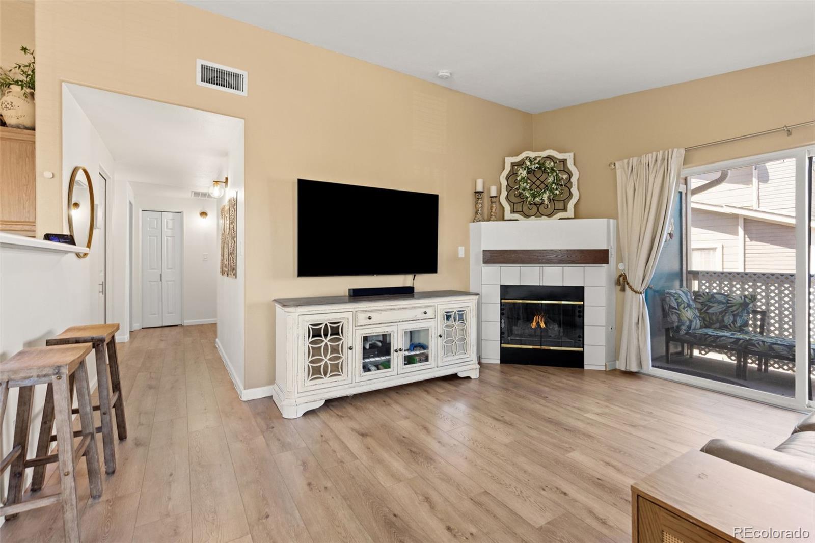 8334 Pebble Creek Way, Unit 201 Highlands Ranch, CO 80126 - Photo 5 of 28 a living room with furniture a flat screen tv and a fireplace