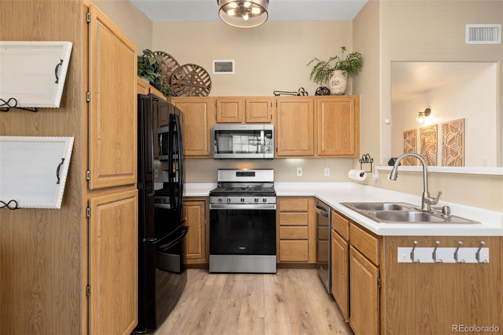 8334 Pebble Creek Way, Unit 201 Highlands Ranch, CO 80126 - Photo 8 of 28 a kitchen with stainless steel appliances granite countertop a sink stove and refrigerator
