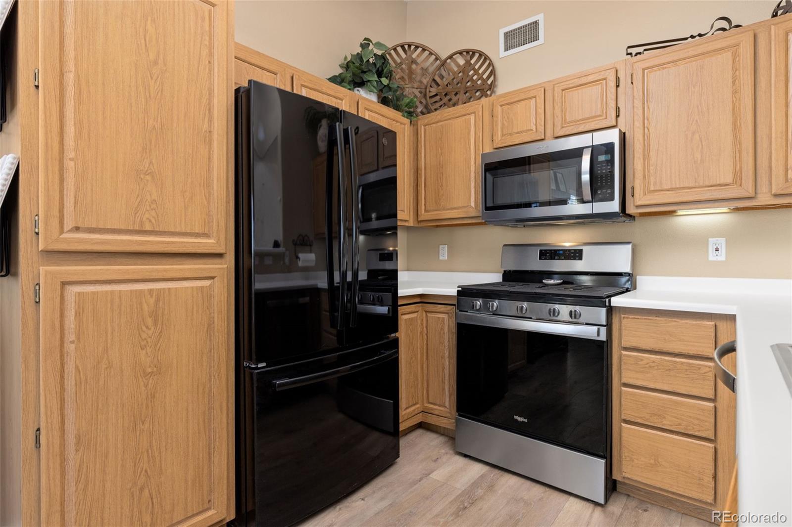 8334 Pebble Creek Way, Unit 201 Highlands Ranch, CO 80126 - Photo 9 of 28 a kitchen with stainless steel appliances white cabinets and a stove top oven