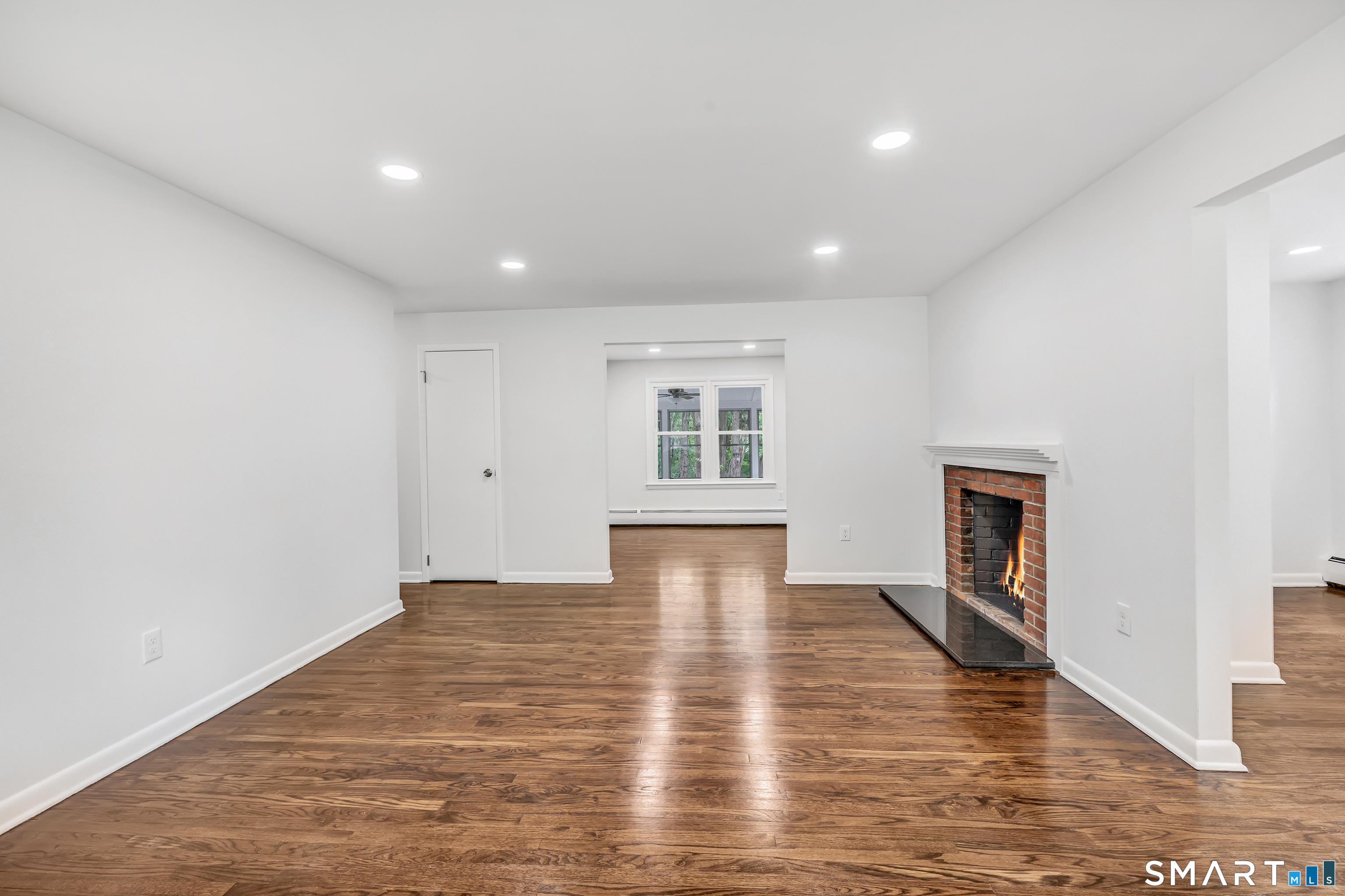 7 Longview Road Newtown, CT 06482 - Photo 3 of 40 a view of empty room with wooden floor and fireplace