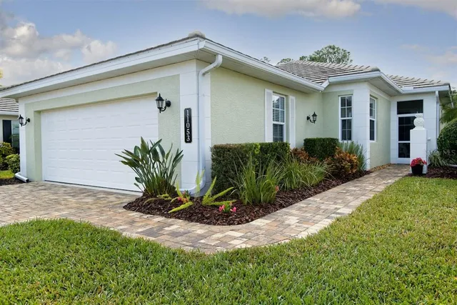 a view of a house with a small yard and plants