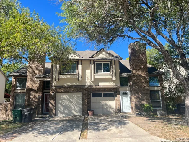 a front view of a house with a tree