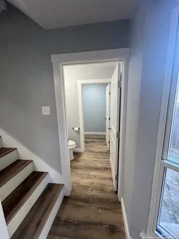 a view of a hallway with wooden floor and staircase