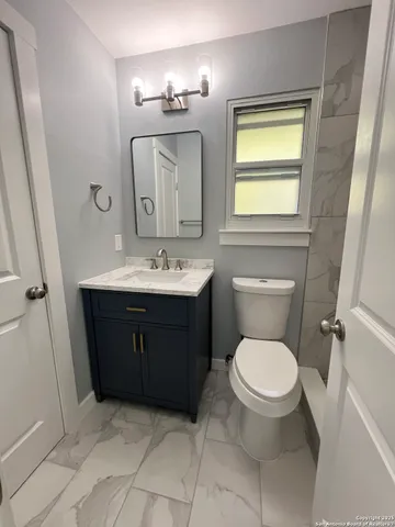 a spacious bathroom with a toilet sink and mirror
