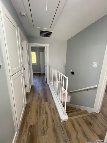 a view of a hallway with wooden floor and staircase