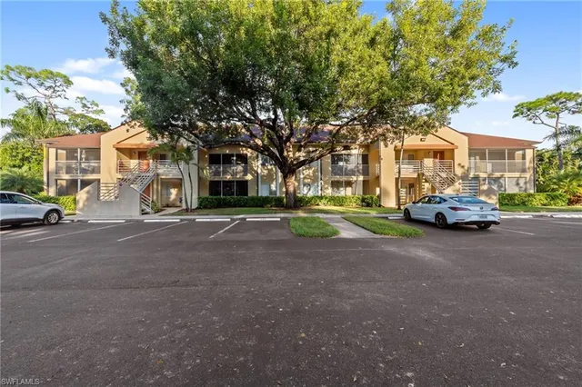 a view of road with card parked on side and retail shops