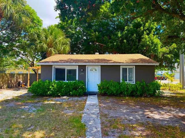a front view of a house with a yard and trees
