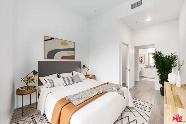 a bedroom with a bed and wooden floor