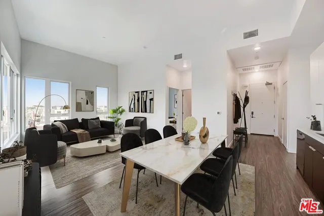 a living room with furniture a wooden floor and next to a window