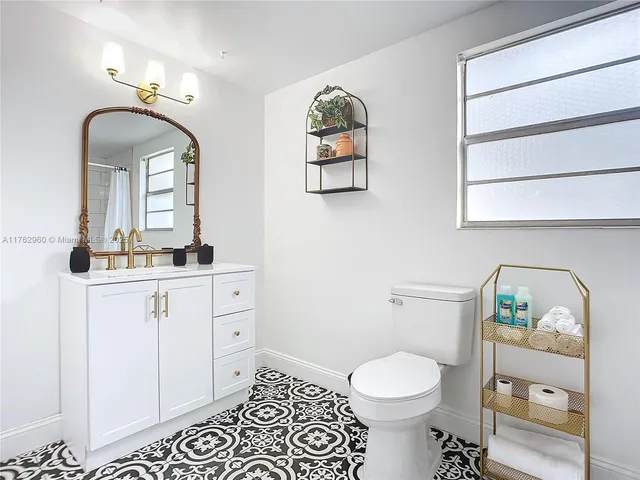 a bathroom with a sink a toilet a mirror and shower