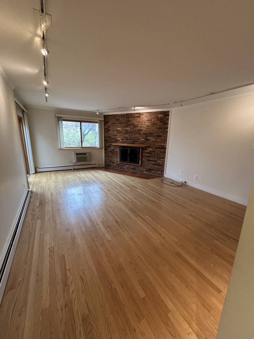 401 West Webster Avenue, Unit 502 Chicago, IL 60614 - Photo 2 of 9 an empty room with wooden floor and fireplace