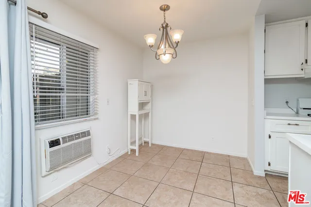 a kitchen with white cabinets and window