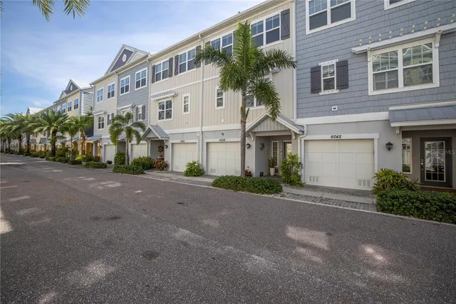 a view of a white building among the street with palm trees