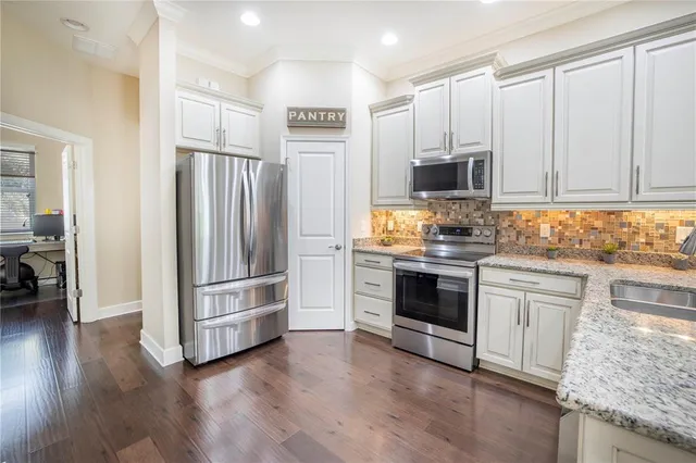 a bathroom with a granite countertop toilet a sink and a window