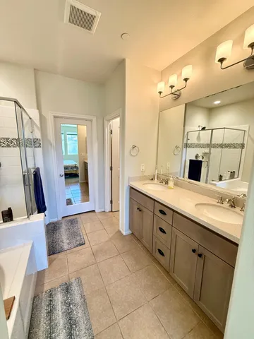 a bathroom with a double vanity sink a mirror and a shower