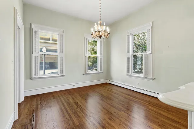 a view of a livingroom with a fireplace wooden floor and a chandelier
