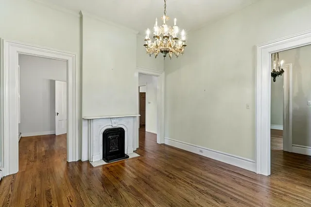 a view of empty room with wooden floor and window