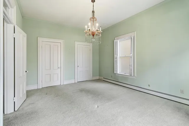 an empty room with windows and chandelier