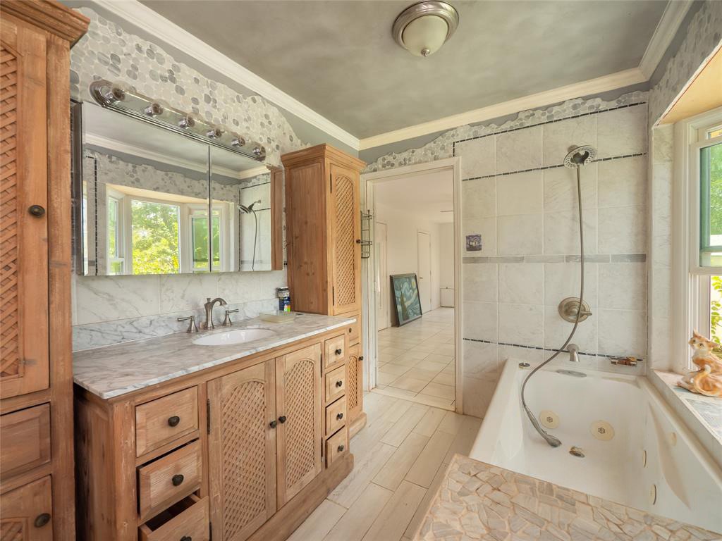 368 Riddle Road Cedar Creek, TX 78612 - Photo 10 of 16 a bathroom with a granite countertop sink mirror and a bathtub