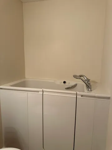 a bathroom with a tub sink and mirror