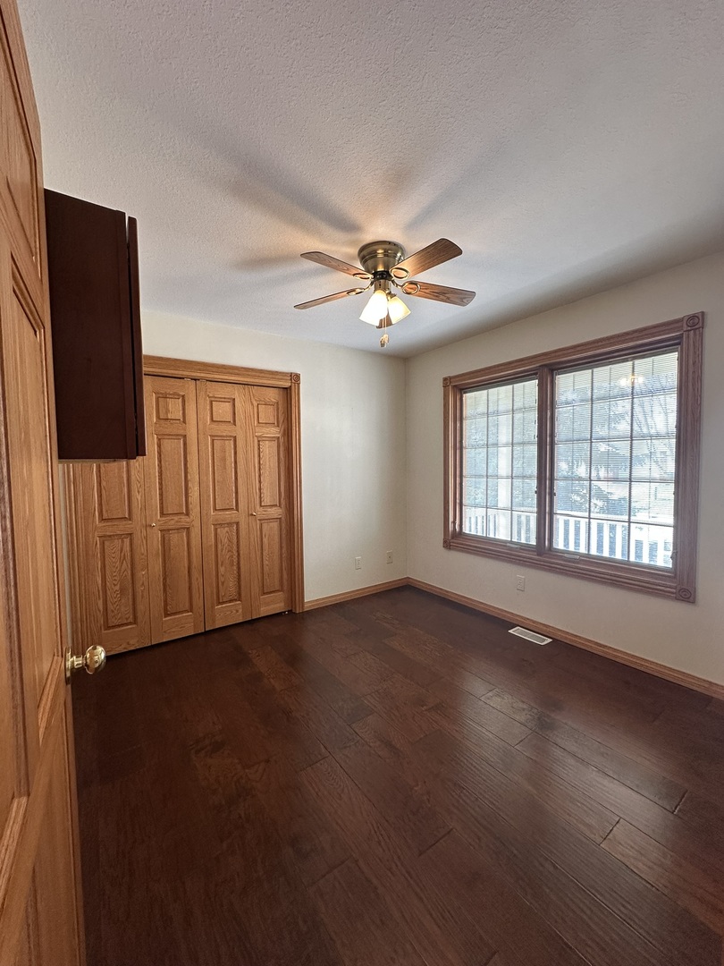 1005 North Fox Run Villa Grove, IL 61956 - Photo 20 of 45 an empty room with wooden floor and windows