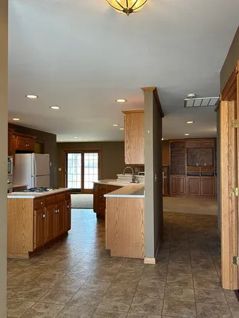 a large kitchen with a refrigerator and a stove top oven