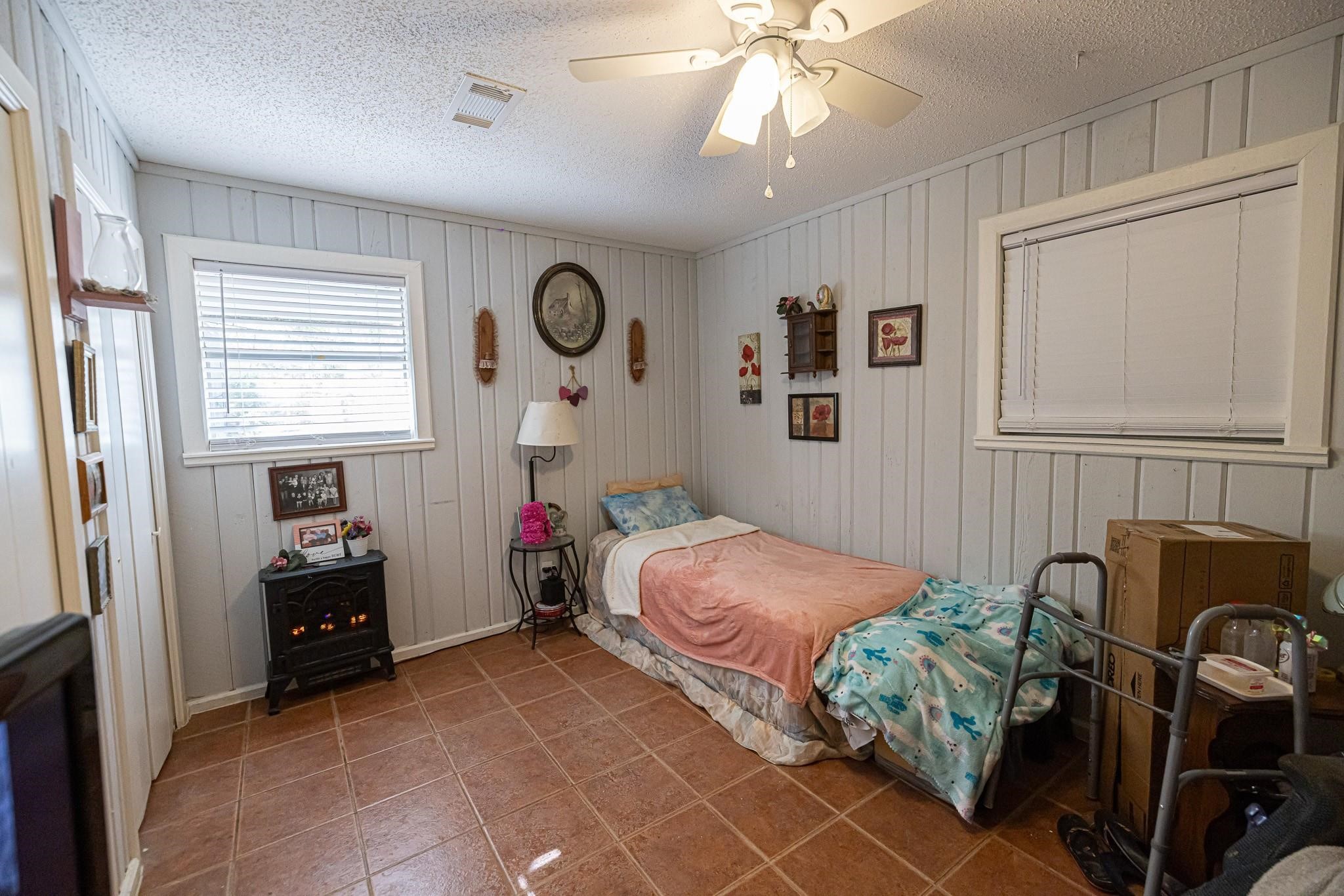 761 North Forest Cove Loop Coldspring, TX 77331 - Photo 13 of 33 a bedroom with a bed and a chandelier