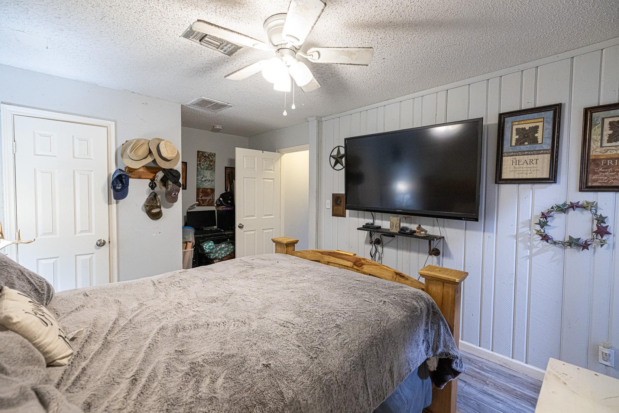 761 North Forest Cove Loop Coldspring, TX 77331 - Photo 15 of 33 a bedroom with a bed and a flat tv screen on dresser