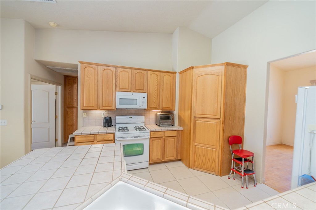 13880 Paramount Road Phelan, CA 92371 - Photo 17 of 54 a kitchen with stainless steel appliances a refrigerator and a stove top oven