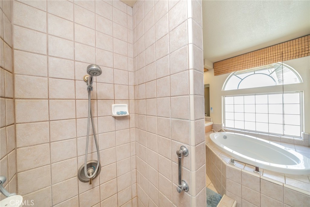 13880 Paramount Road Phelan, CA 92371 - Photo 23 of 54 a bathroom with a tub a sink a window and a shower