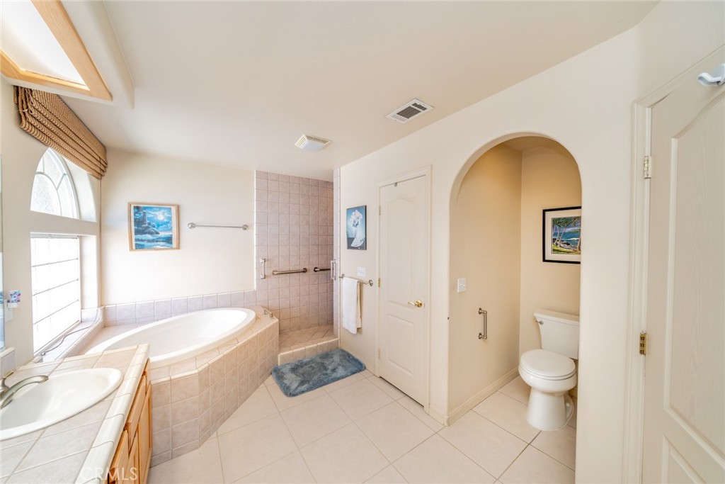 13880 Paramount Road Phelan, CA 92371 - Photo 24 of 54 a bathroom with a granite countertop sink toilet a shower and a bathtub