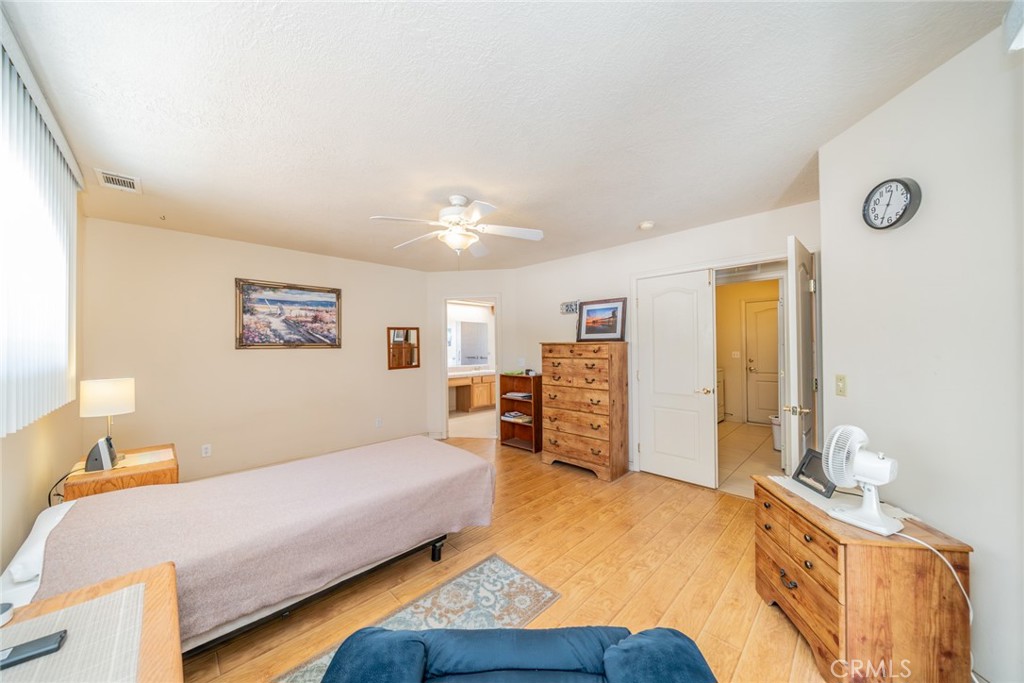 13880 Paramount Road Phelan, CA 92371 - Photo 25 of 54 a bedroom with a bed and wooden floor