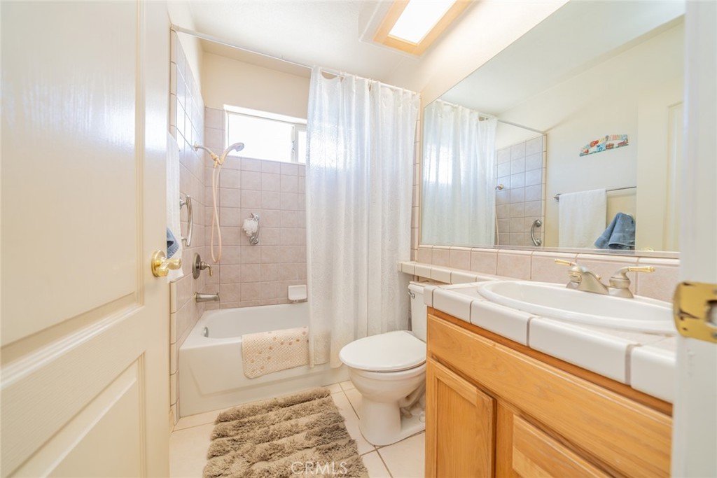 13880 Paramount Road Phelan, CA 92371 - Photo 29 of 54 a bathroom with a sink a toilet a mirror and bathtub