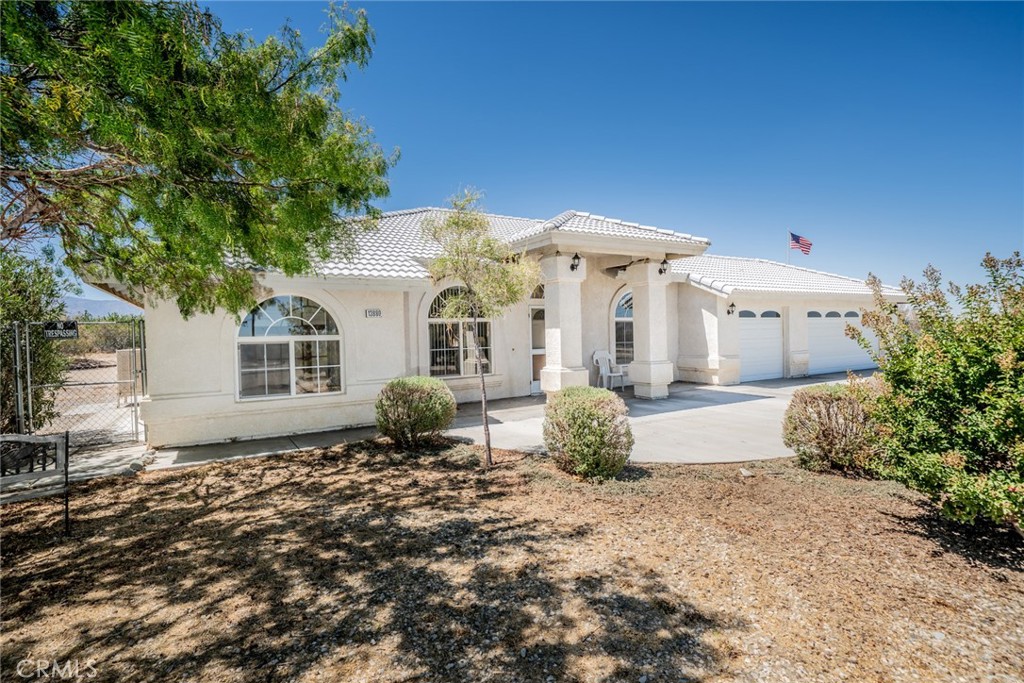 13880 Paramount Road Phelan, CA 92371 - Photo 4 of 54 a front view of a house with a garden