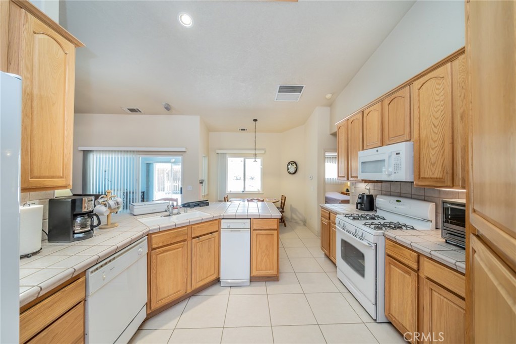 13880 Paramount Road Phelan, CA 92371 - Photo 10 of 54 a kitchen with stainless steel appliances a stove sink and cabinets