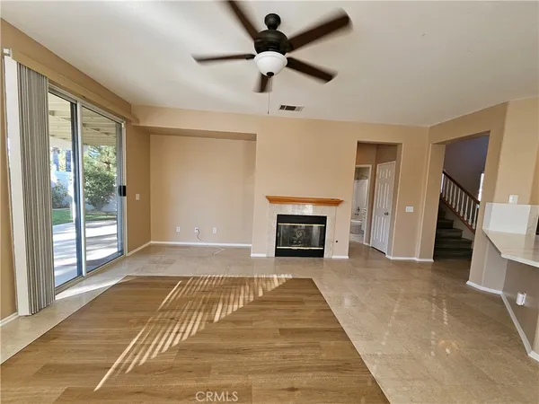 a view of an empty room with a fireplace and a window