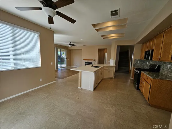 a kitchen with stainless steel appliances kitchen island granite countertop a stove and a sink