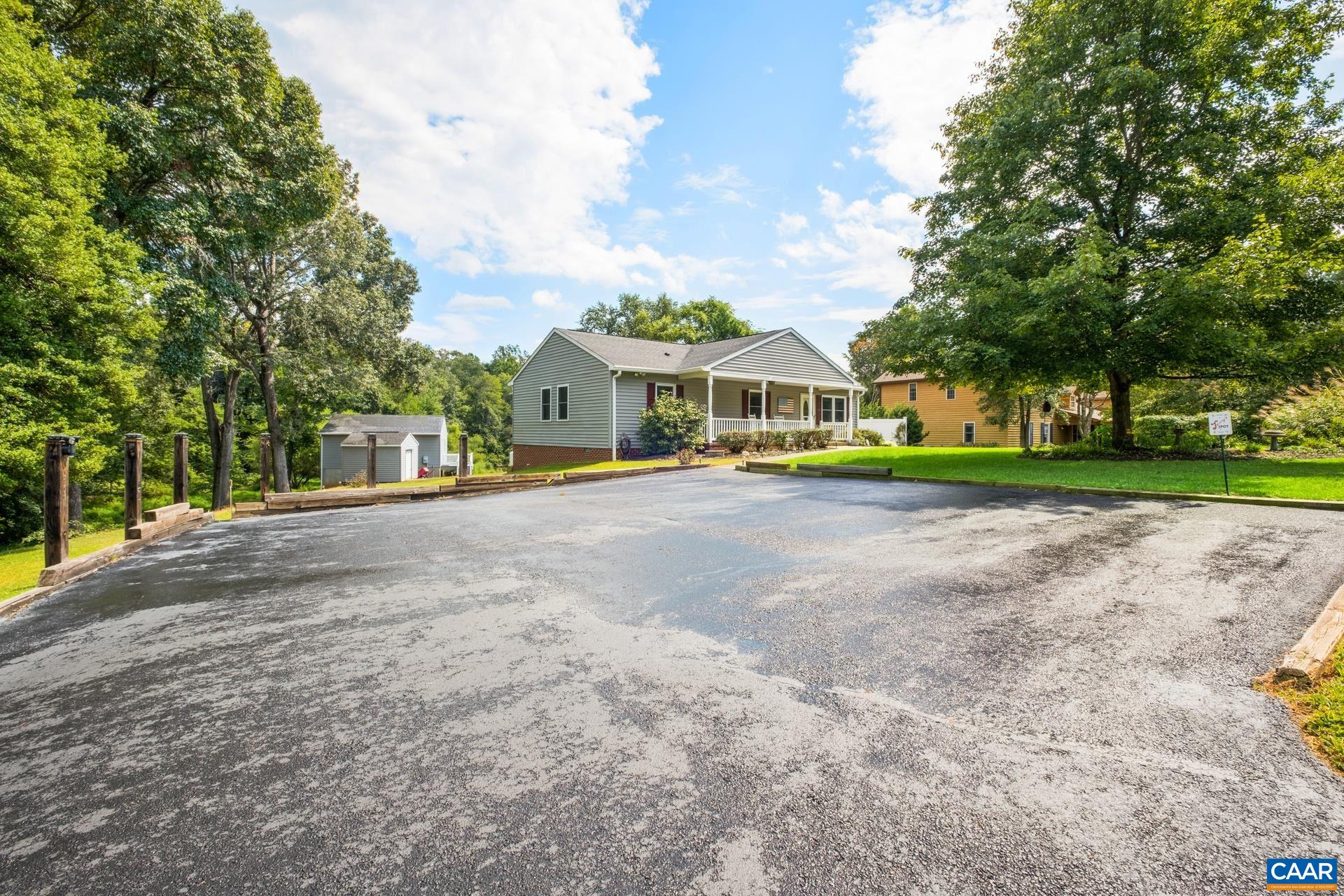162 Rolling Hills Road Ruckersville, VA 22968 - Photo 8 of 48 a view of a white house with a big yard and large trees