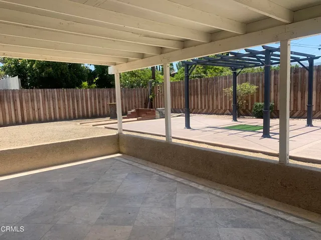 a view of swimming pool with table and chairs with wooden fence