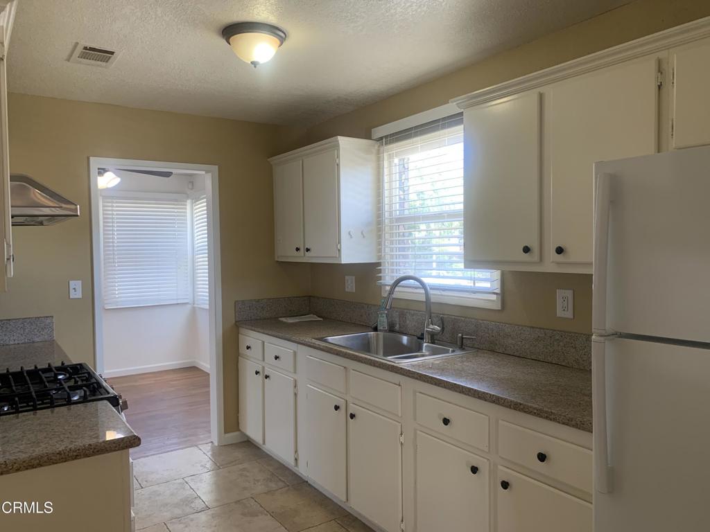 938 Ford Street Corona, CA 92879 - Photo 7 of 36 a kitchen with granite countertop a sink stove and refrigerator