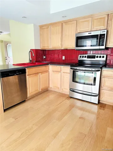 a kitchen with stainless steel appliances a stove a microwave and a sink
