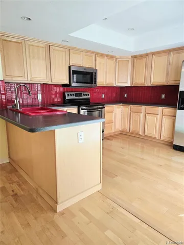 a kitchen with stainless steel appliances granite countertop a stove a sink and a microwave