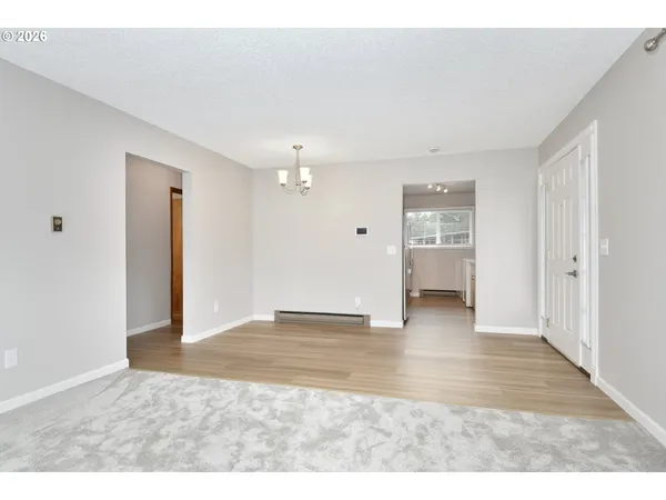 a view of an empty room with a window and bathroom
