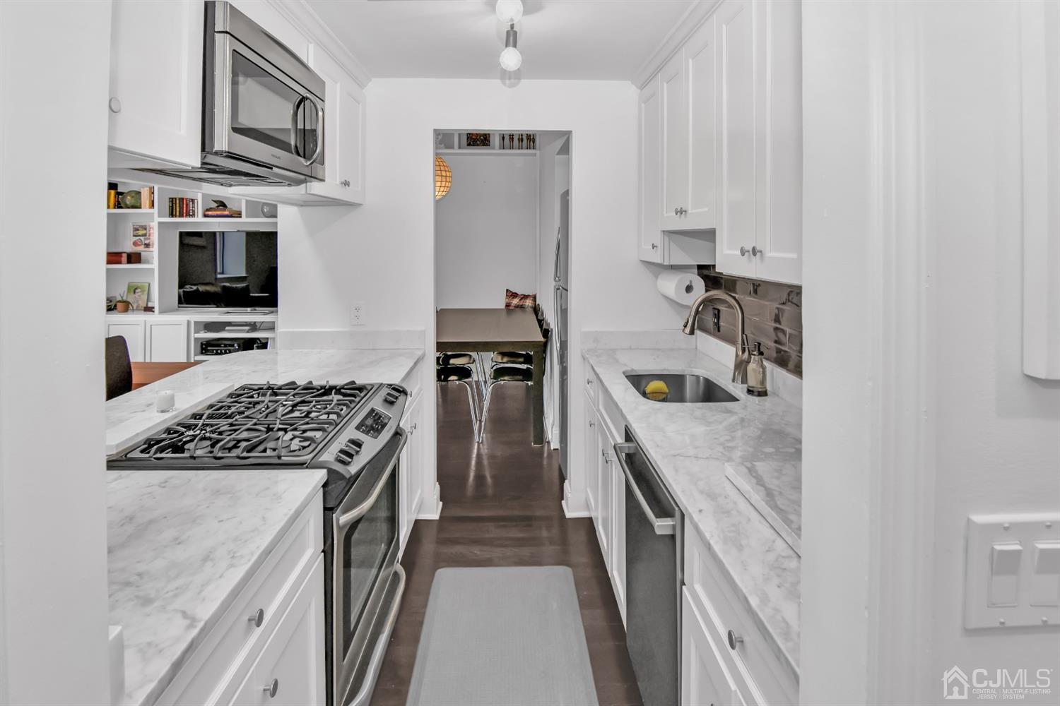 222 Clinton Street, Unit 23 Hoboken, NJ 07030 - Photo 5 of 12 a kitchen with stainless steel appliances granite countertop a stove sink microwave and cabinets