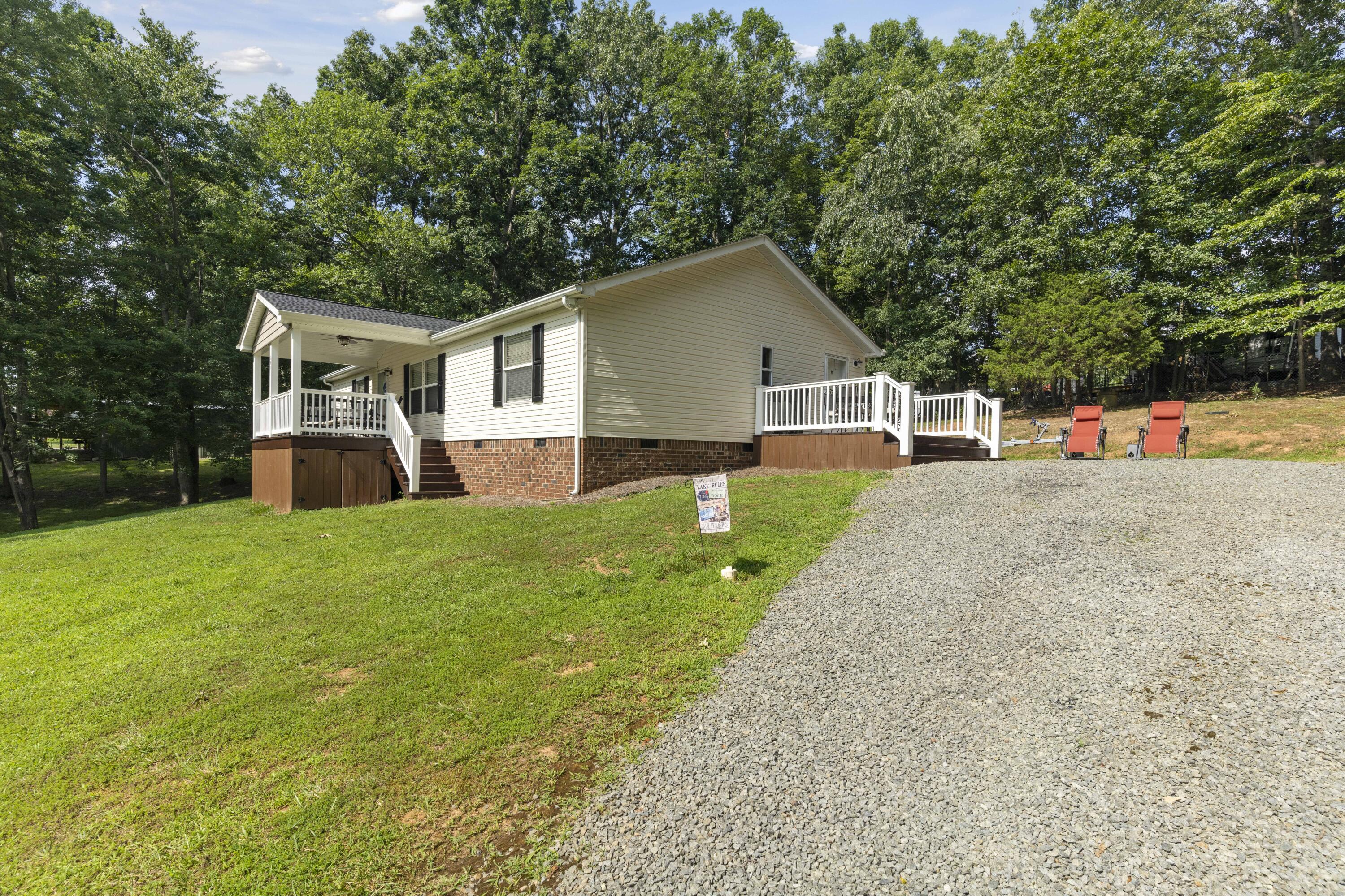 391 Cool Branch Road Penhook, VA 24137 - Photo 12 of 54 a front view of house with yard and trees in the background