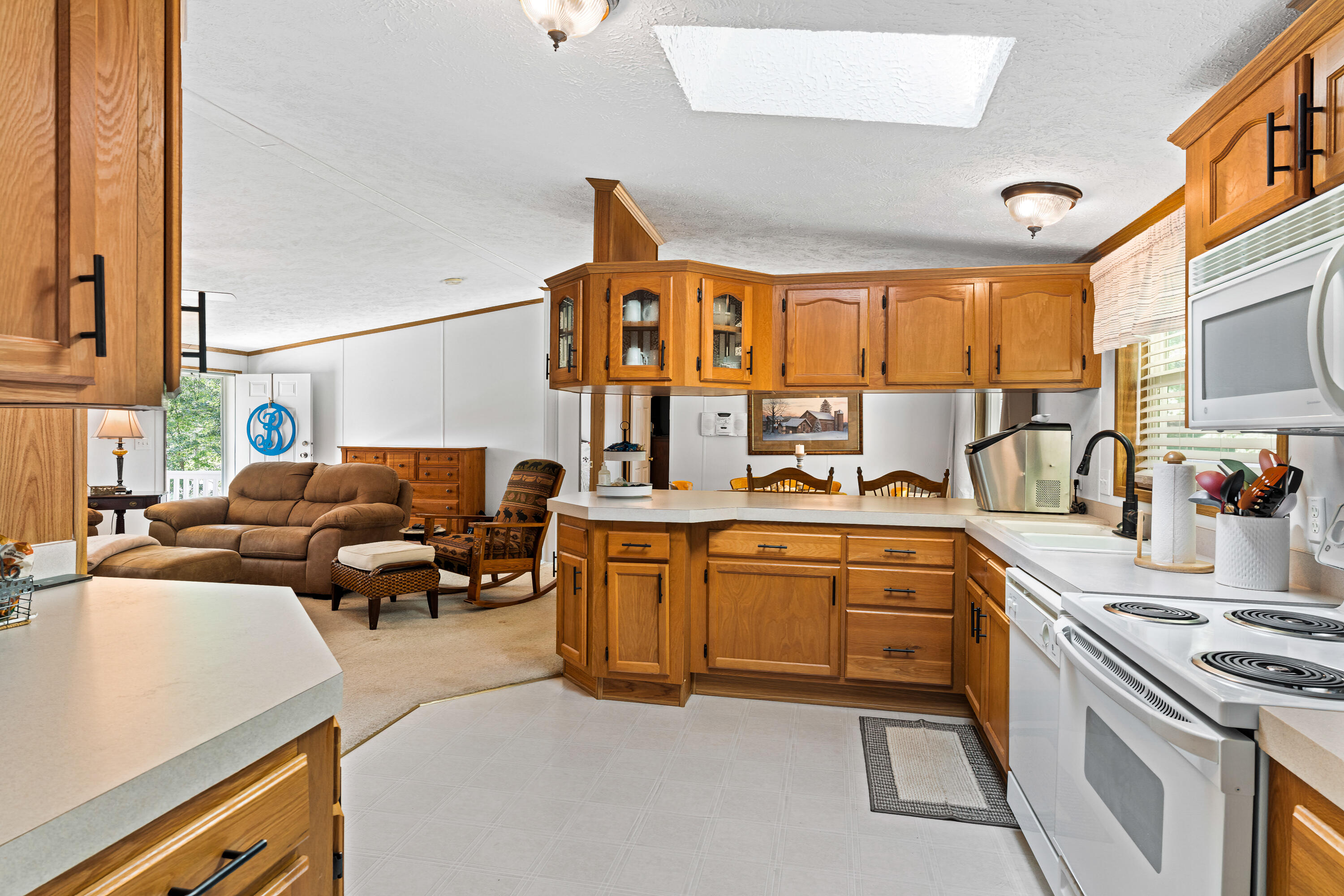 391 Cool Branch Road Penhook, VA 24137 - Photo 26 of 54 a large white kitchen with stainless steel appliances granite countertop a stove and a refrigerator