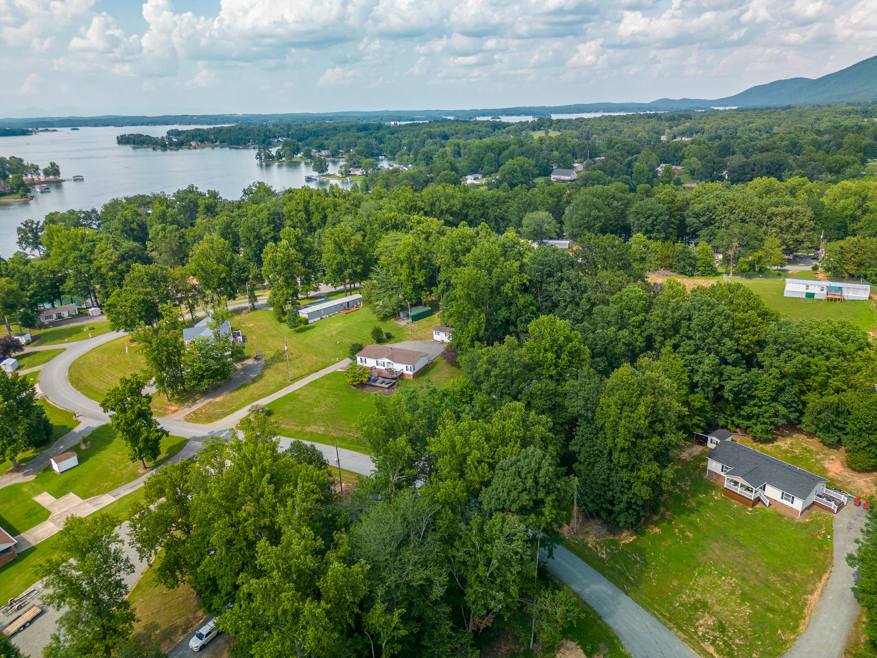 391 Cool Branch Road Penhook, VA 24137 - Photo 52 of 54 an aerial view of lake residential house with outdoor space and trees all around